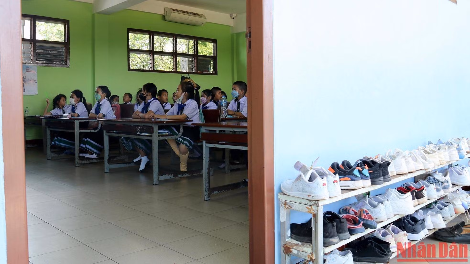 Shoes are neatly arranged outside the classroom door.