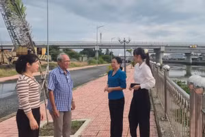 Nguyen Van Tho, Secretary of the Hamlet 2 Party Cell (second from left), accompanies commune officials to inspect a completed embankment and erosion-control project that serves approximately 45 households.