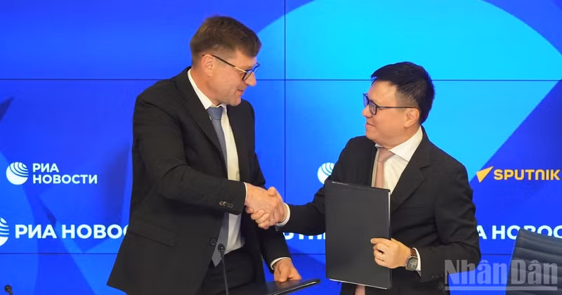 Editor-in-Chief of Nhan Dan Newspaper Le Quoc Minh and First Deputy Editor-in-Chief of Rossiya Segodnya Sergey Kochetkov exchange the signed cooperation agreement. (Photo: THANH THE)