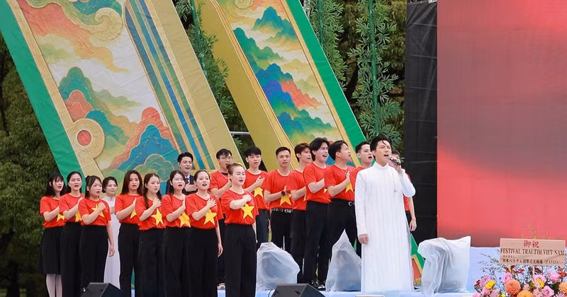 Singer Anh Tu joins 34 overseas Vietnamese in singing the Vietnamese National Anthem. (Photo: Organising Committee)