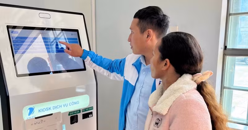 Youth union members in Lac Duong Commune, Lam Dong Province, assist residents in obtaining queue numbers at an online public service kiosk. (Photo: Lam Dong Newspaper)