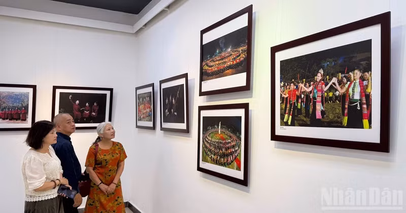 Visitors admire the photographic works on display.