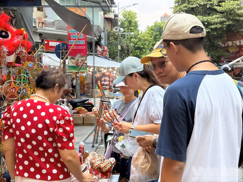 Tourists show interest in folk toys such as traditional drums.