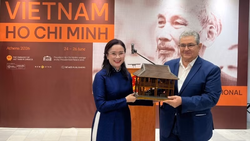 Le Thi Phuong, Director of the Ho Chi Minh Memorial Site at the Presidential Palace, presents a model of President Ho Chi Minh’s stilt house to Dimitris Koutsoumpas, General Secretary of the Communist Party of Greece. (Photo: Organising Committee)