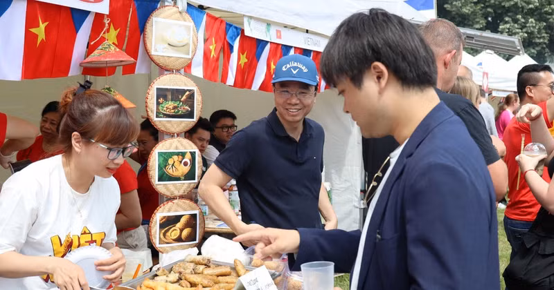 Visitors purchase food at the Vietnamese Embassy’s booth. (Photo: VNA)