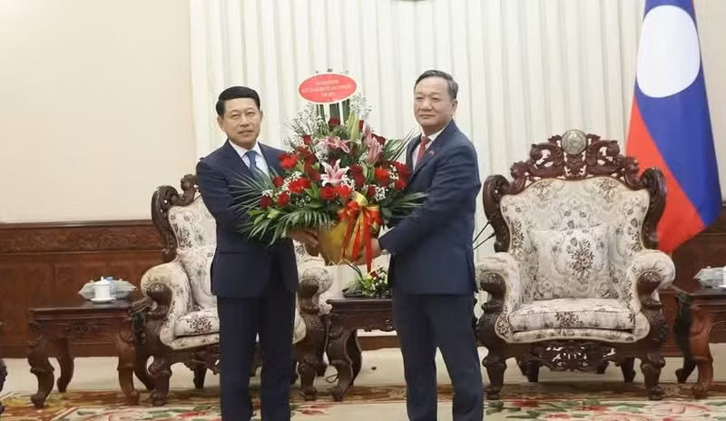 Vietnamese Ambassador to Laos Nguyen Minh Tam (R) hands over flowers from Prime Minister Le Minh Hung to congratulate Lao PM Saleumxay Kommasith. (Photo: VNA)