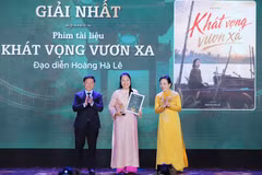 Director Hoang Ha Le (C) receives the first prize at the award ceremony 
