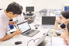 Japanese experts and Vietnamese researchers discuss at the national key laboratory for advanced materials for green development, Viet Nam National University, Ha Noi. (Photo: HA LINH)