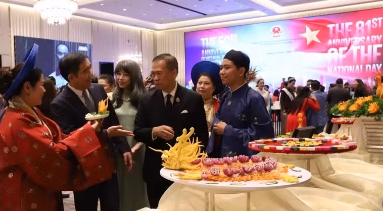 Ambassador Pham Viet Hung (second, left) introduces the unique "nem cong" (peacock spring rolls) of Hue royal cuisine to Thai Vice Minister of Foreign Affairs Vijavat Isarabhakdi (Photo: VNA)
