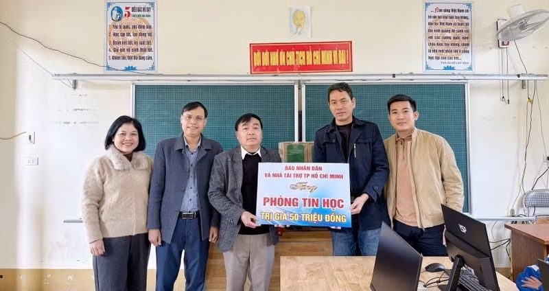 Representatives of Nhan Dan Newspaper in Nghe An present a set of computers to Thach Giam 2 Primary School in Tuong Duong Commune.