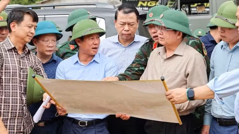 Deputy Prime Minister Ho Quoc Dung and the delegation inspect the scene of the flash flood in Muong Than commune. (Photo: NDO)