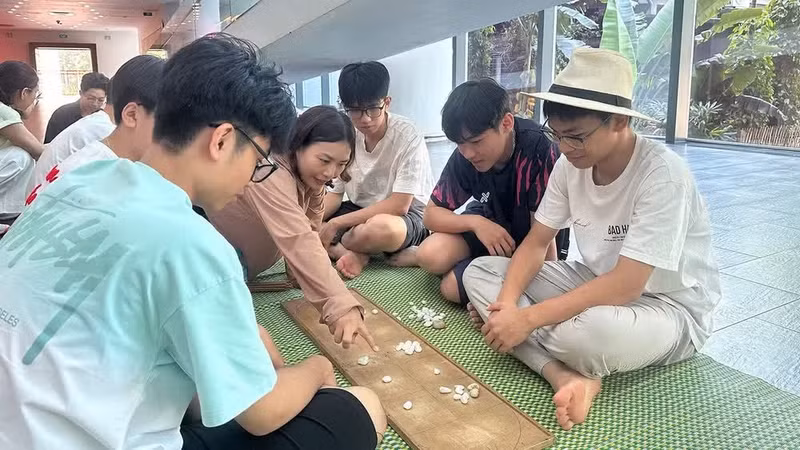 Children experience the traditional Vietnamese board game of “O An Quan”. (Photo courtesy of the Viet Nam Museum of Ethnology)
