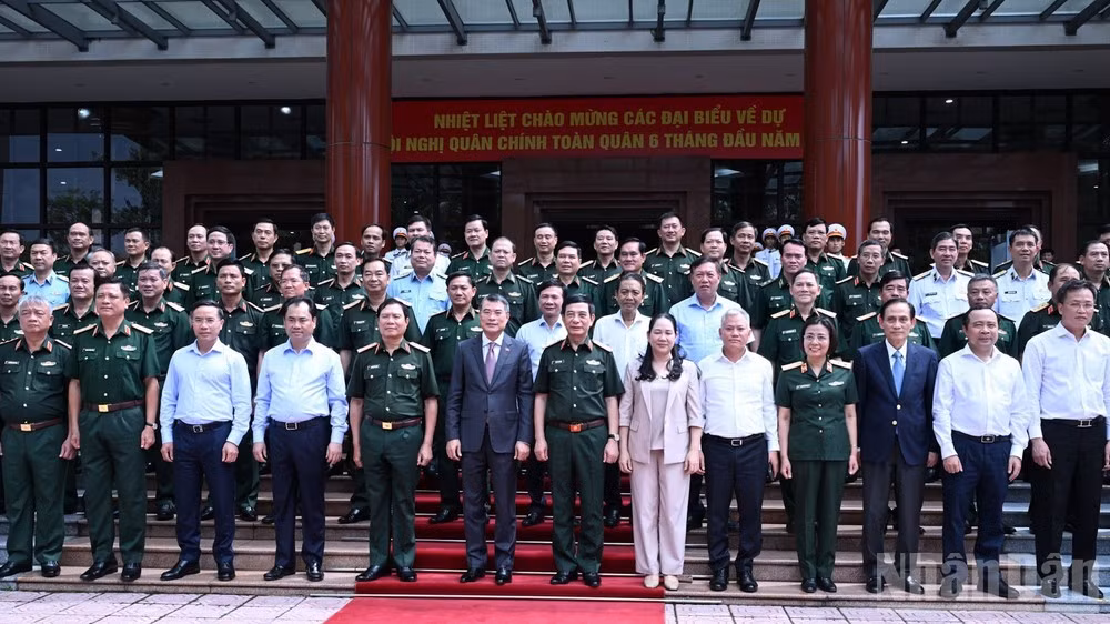 Prime Minister Le Minh Hung poses for a photo with delegates at the national political-military conference. (Photo: NDO)