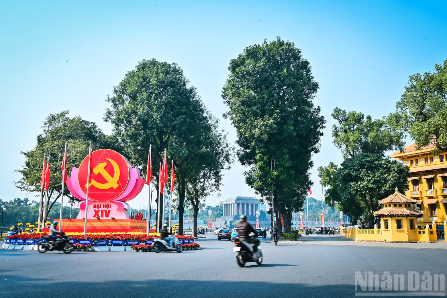 At the Dien Bien Phu–Doc Lap–Chu Van An intersection, decorative clusters featuring the hammer-and-sickle symbol of the Party flag alongside the National Flag are arranged in a harmonious and solemn manner.