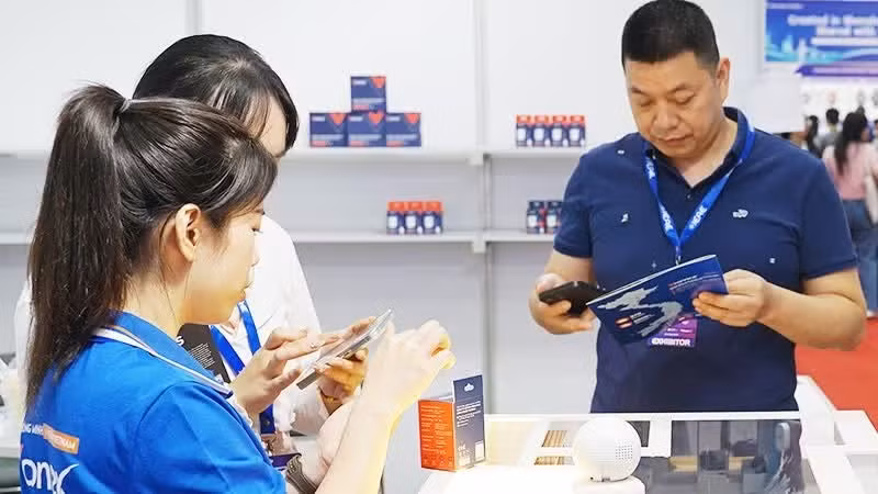 Customers use smartphones to access product information through QR codes. Photo: NAM ANH