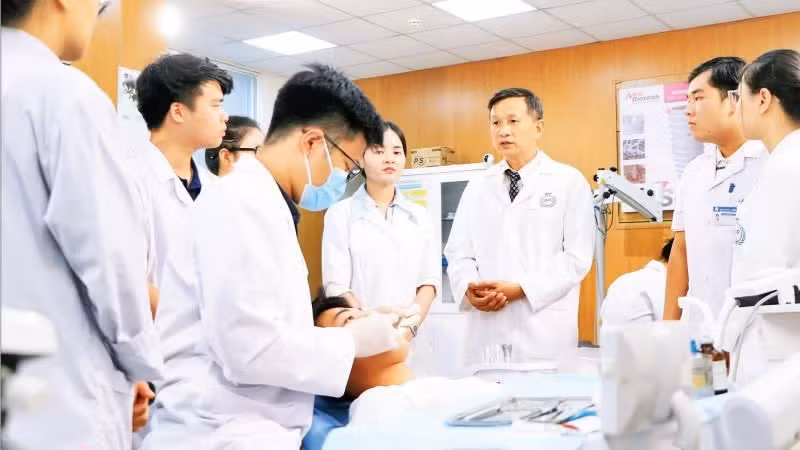 Assoc. Prof. Dr. Pham Nhu Hai, Vice Rector of the University of Medicine and Pharmacy (Viet Nam National University, Ha Noi), guides students in clinical dental practice.