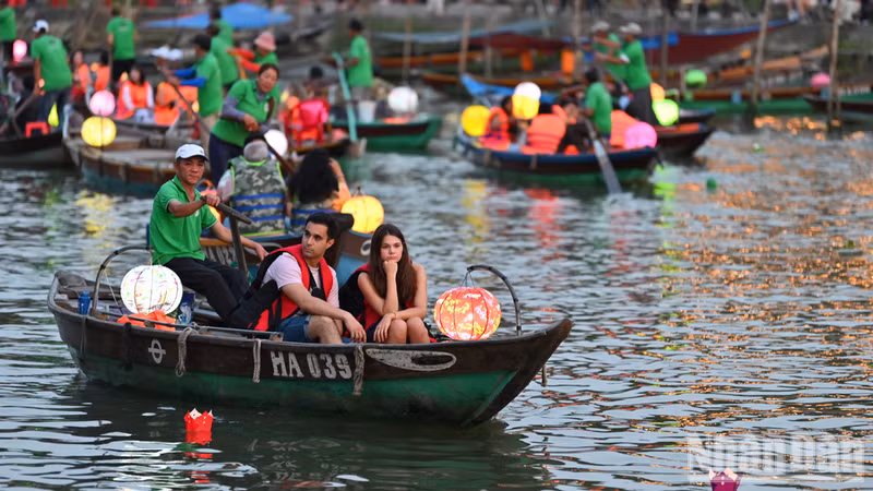 International tourists release flower lanterns on the Hoai River in Hoi An. (Photo: THE DAI)