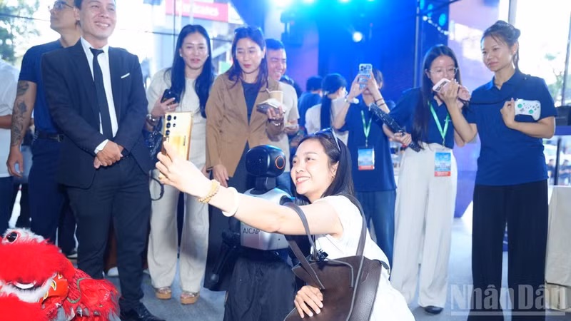 Delegates pose for a photo with robots at the event. (Photo: NDO)