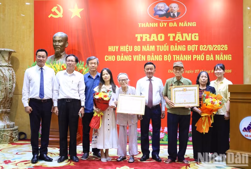 Politburo member and Permanent Member of the Party Central Committee’s Secretariat Tran Cam Tu presents 80-year Party Membership Badges at the Da Nang City Party Committee.