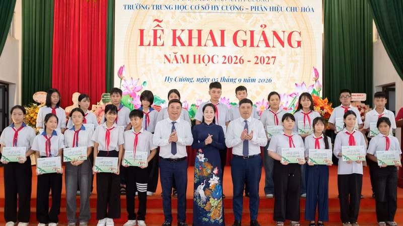 Representatives of the National Fund for Vietnamese Children and Vietcombank present scholarships to students facing difficult circumstances at the programme. (Photo: NFVC)