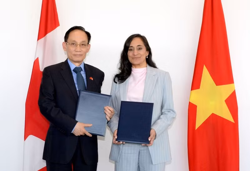 Vietnamese Minister of Foreign Affairs Le Hoai Trung (left) and his Canadian counterpart adopt an Action Plan (Photo: VNA)
