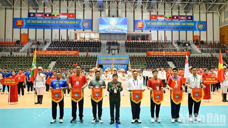 Lieutenant General Nguyen Ba Luc, Deputy Chief of the General Staff of the Viet Nam People's Army and Head of the Organising Committee, presents commemorative flags to representatives of the participating teams.