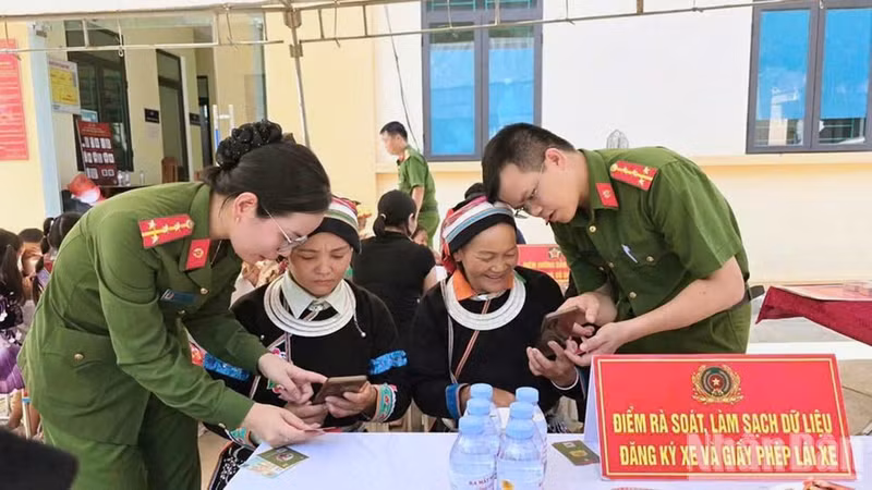 An officer of Thuan Hoa Commune Public Security guides residents in using digital transformation applications.