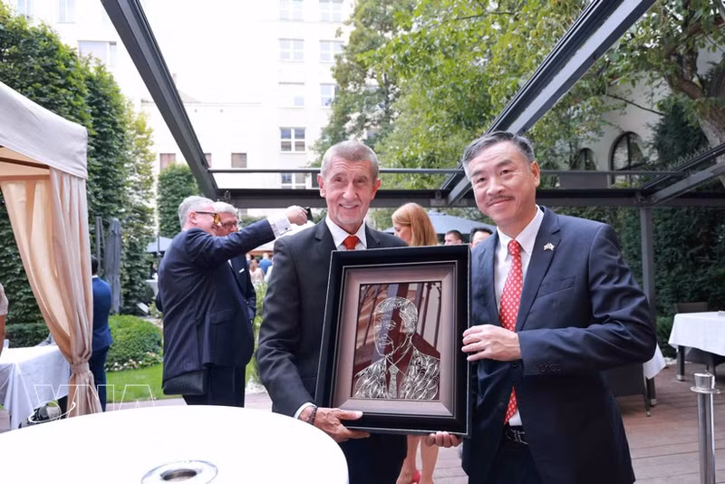 Vietnamese Ambassador to the Czech Republic Duong Hoai Nam (right) presents Prime Minister Andrej Babiš with an illustrated portrait of the Czech PM (Photo: VNA)