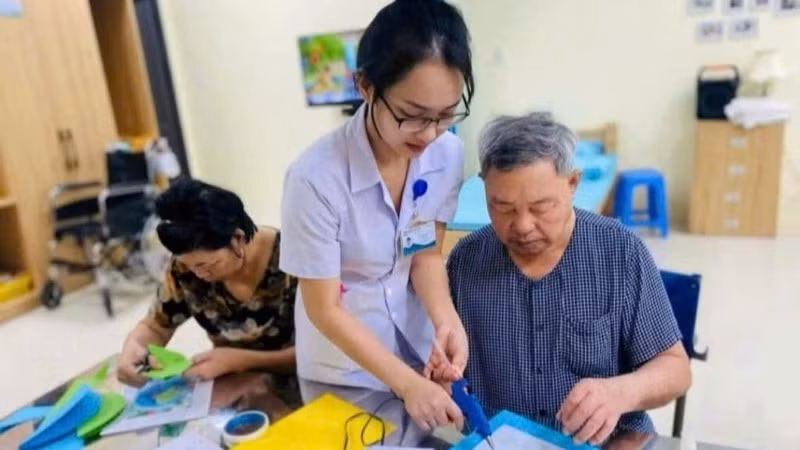 Healthcare workers assist older people with rehabilitation at the Da Nang Elderly Healthcare Centre. (Photo: NDO)
