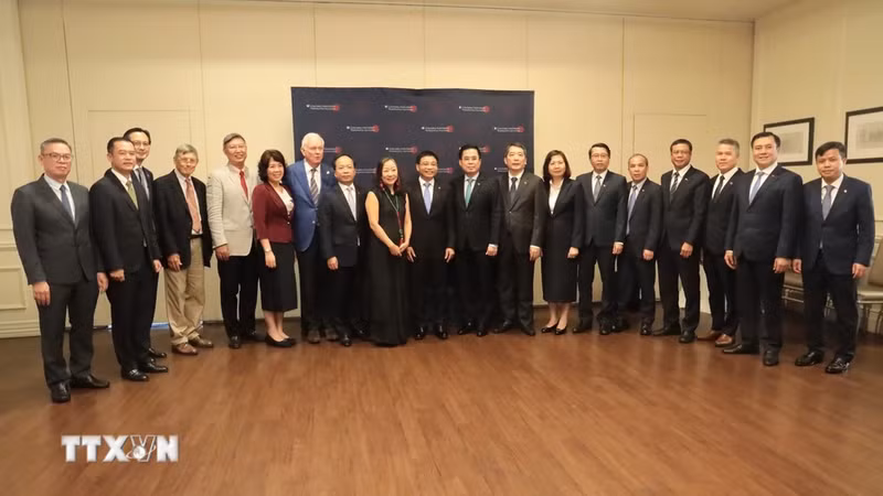 Deputy Prime Minister Nguyen Van Thang (centre) and the Vietnamese delegation pose for a photo with US professors. (Photo: VNA)