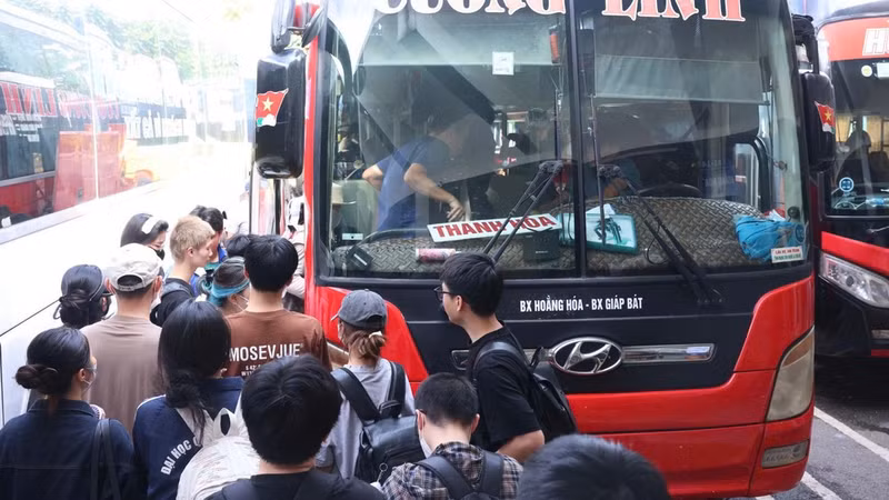 Passengers board a coach at Giap Bat Bus Station in Ha Noi to return home for the holiday. (Photo: HUNG KHANH)