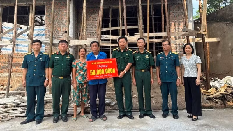 Veteran Pham Van Luong (centre) receives support to build a new home. (Photo: NGOC LAN)