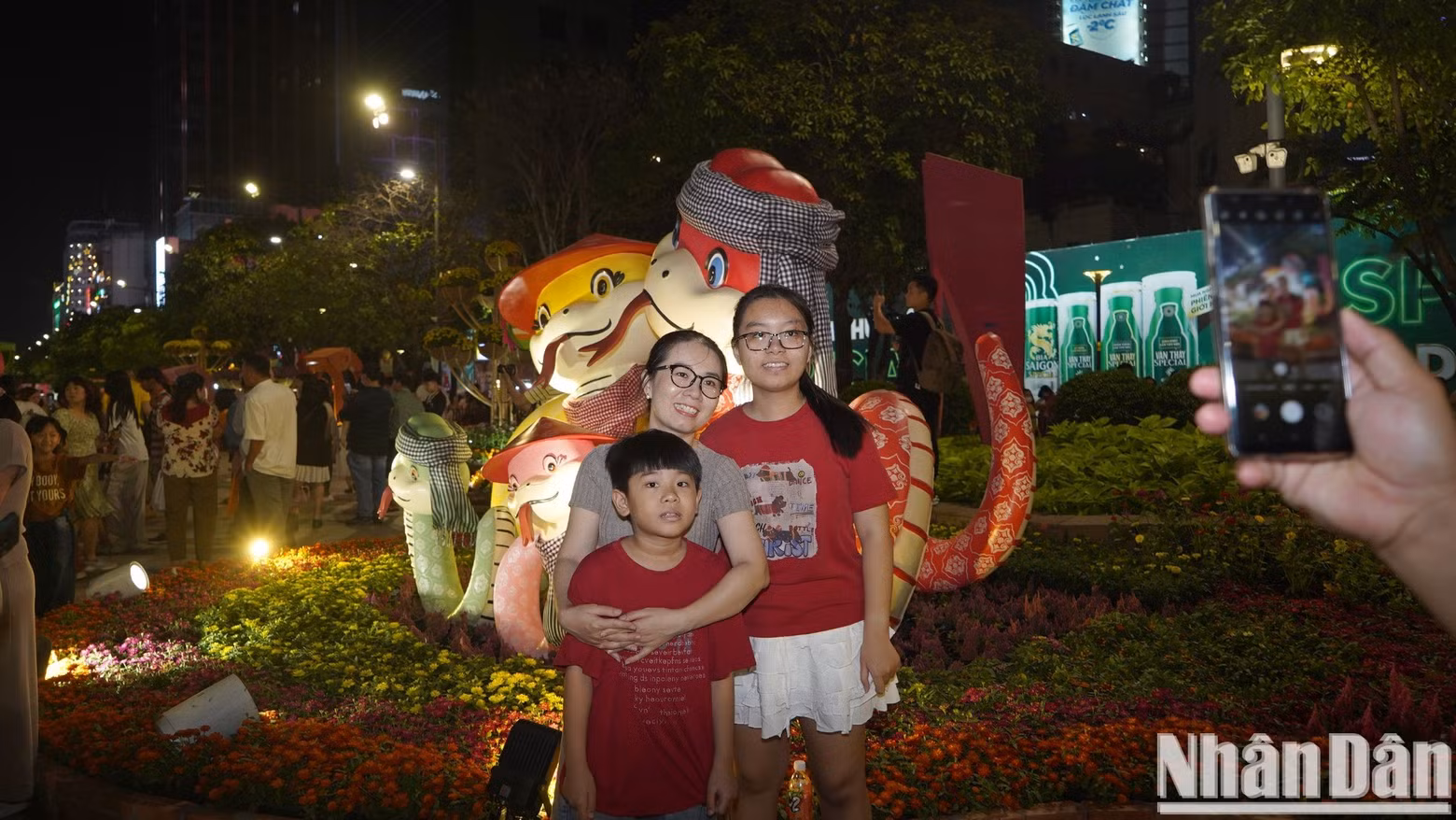 A family pose for a photo with cute snakes.