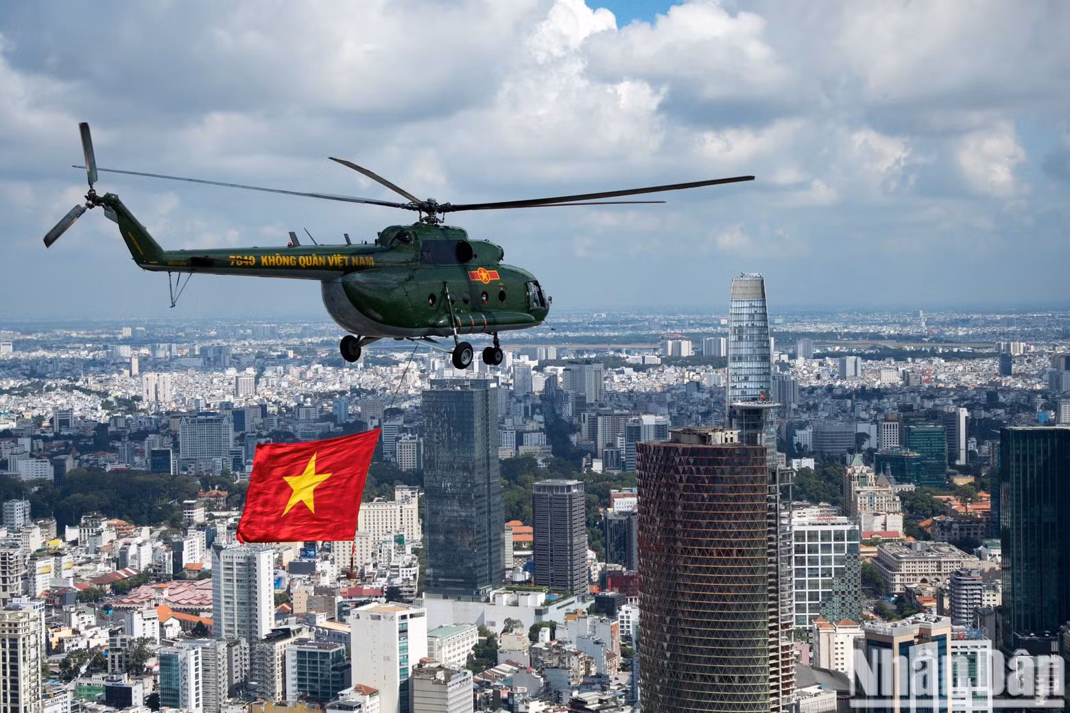 A helicopter pulling the national flag flies past the Bitexco building (District 1). A helicopter pulling the national flag flies past the Bitexco building (District 1).
