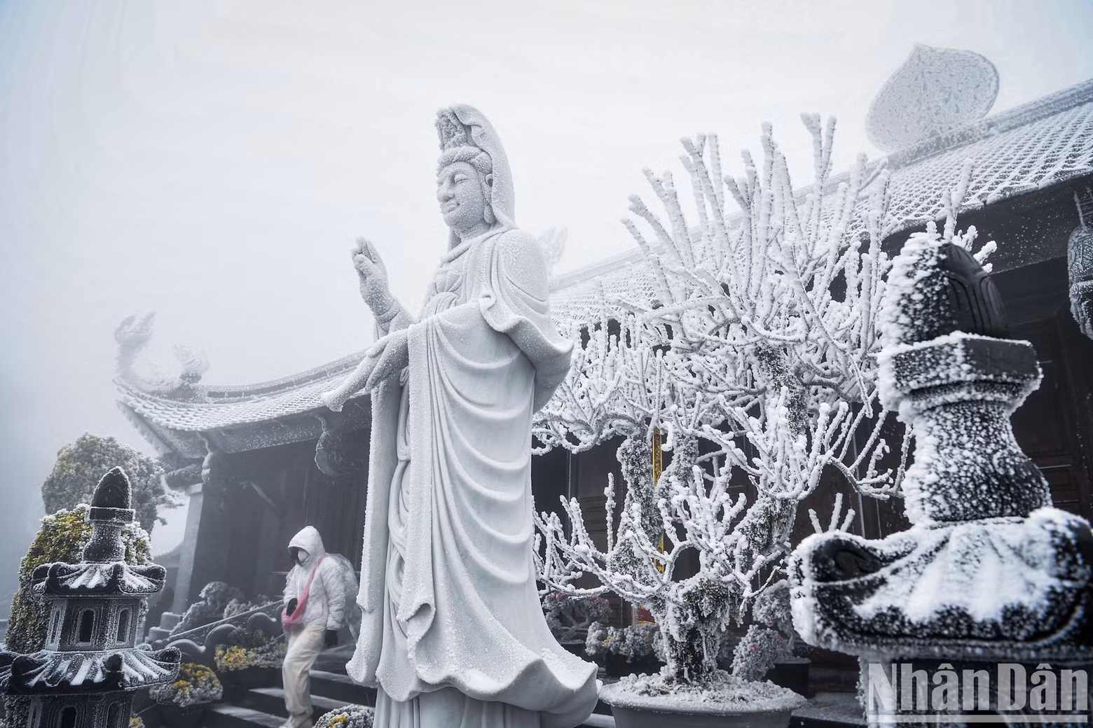 The statue of Avalokitesvara is covered in snow.