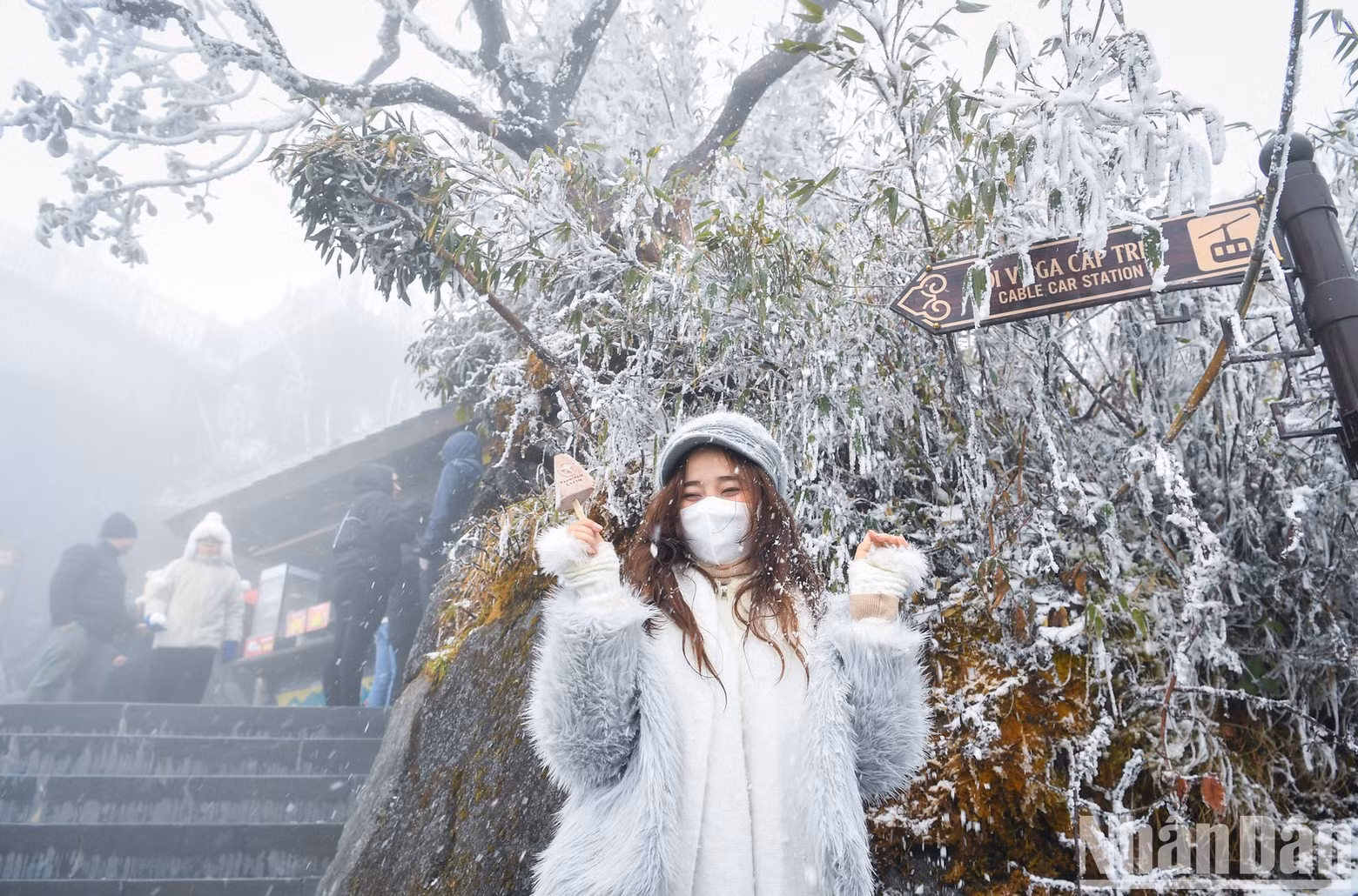 Visitors pose for photos with snow and frost.