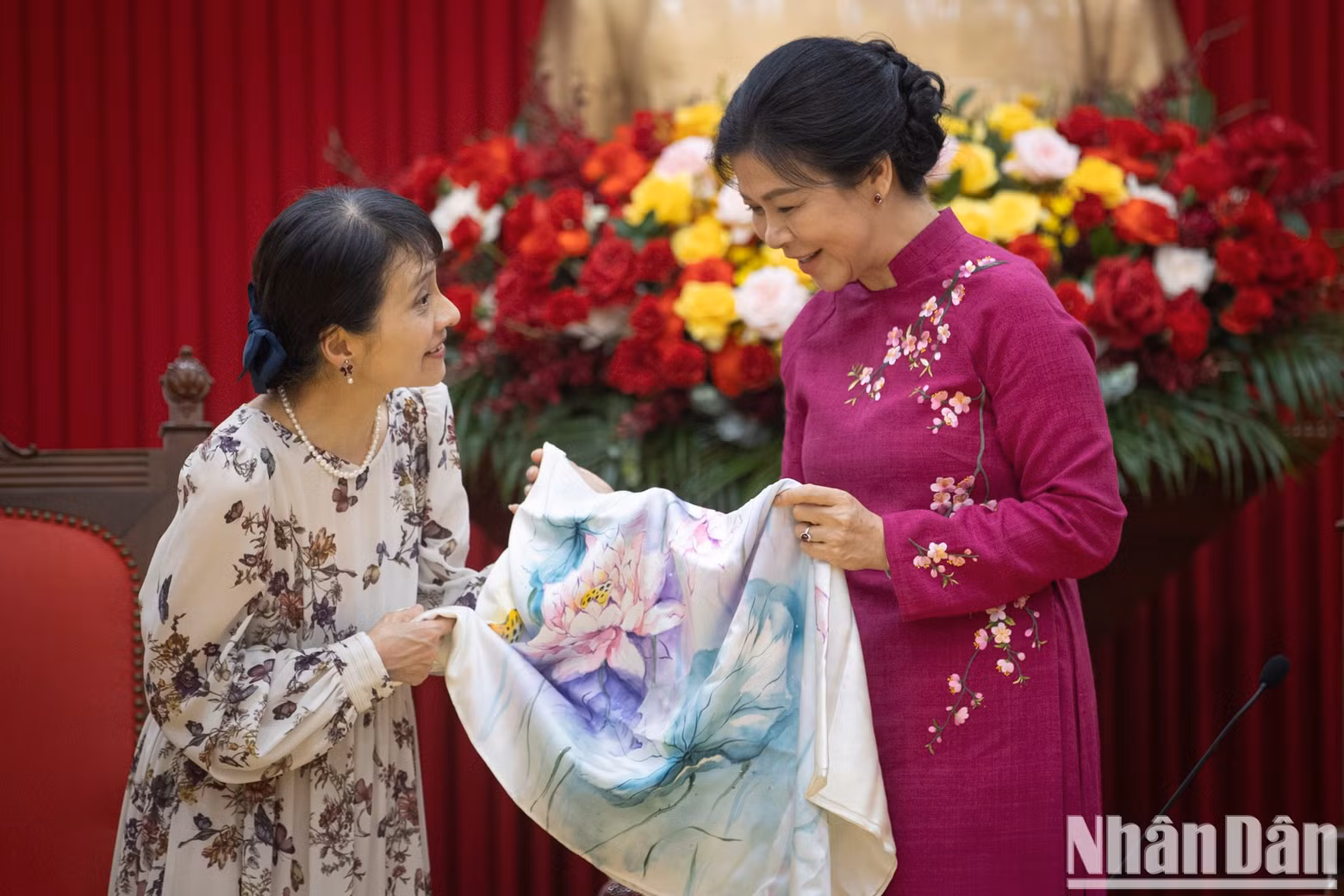 Lady Ngo Phuong Ly presents a silk scarf with lotus and chrysanthemum patterns to Lady Ishiba Yoshiko.