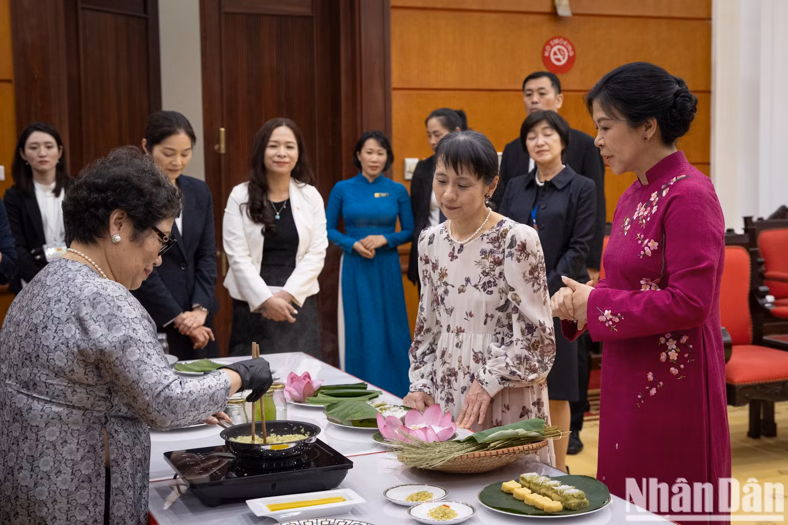 The two ladies make banh com together.