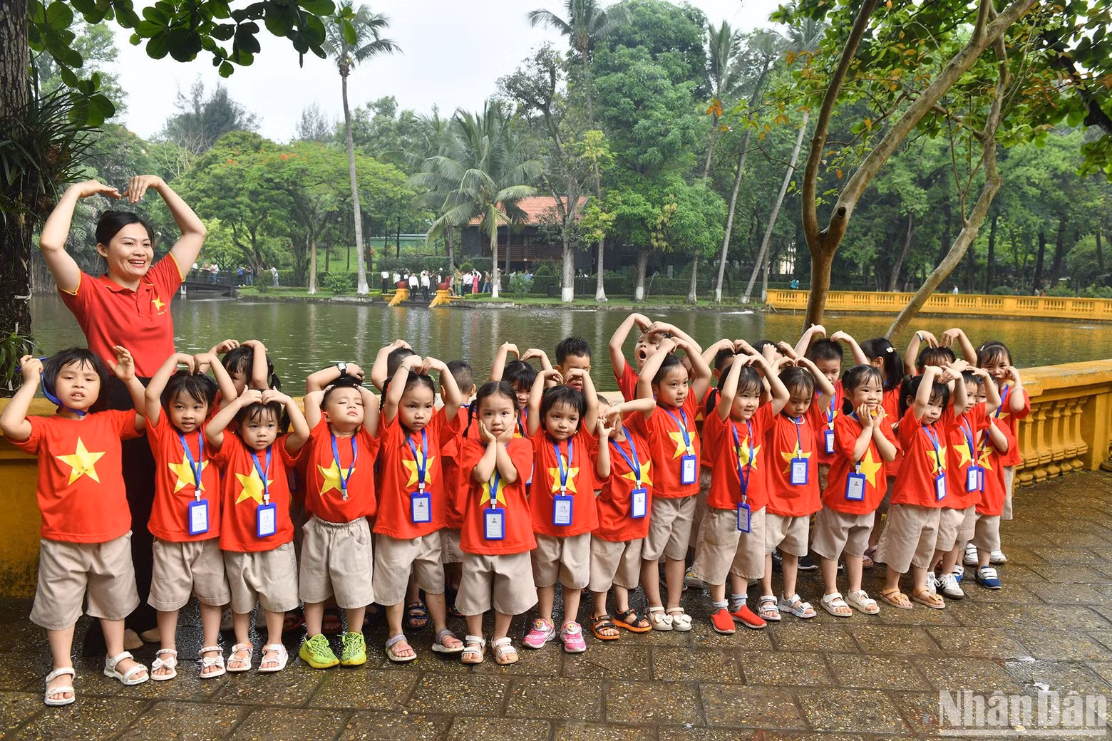 Children pose for a group photo in front of the pond. Children pose for a group photo in front of the pond.