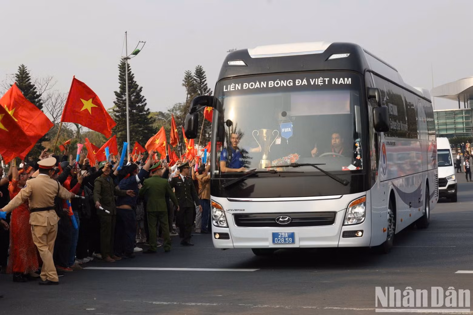 Forward Tien Linh sat at the front of the bus with the ASEAN Cup trophy.