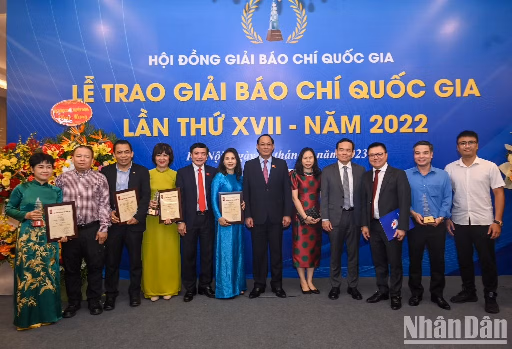 Deputy PM Tran Luu Quang and National Assembly Vice Chairman Tran Quang Phuong pose for a photo with winning journalists of Nhan Dan.
