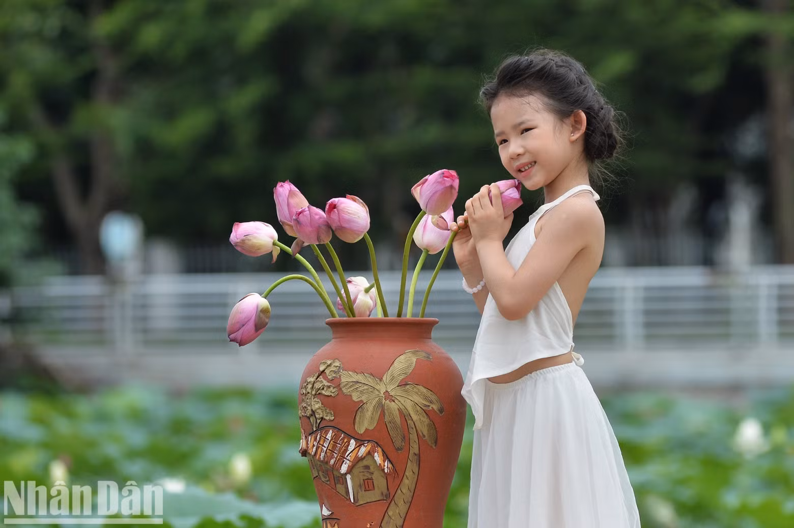 Six-year-old Ha Linh from Ba Dinh District poses for photos with lotus flowers. Six-year-old Ha Linh from Ba Dinh District poses for photos with lotus flowers.