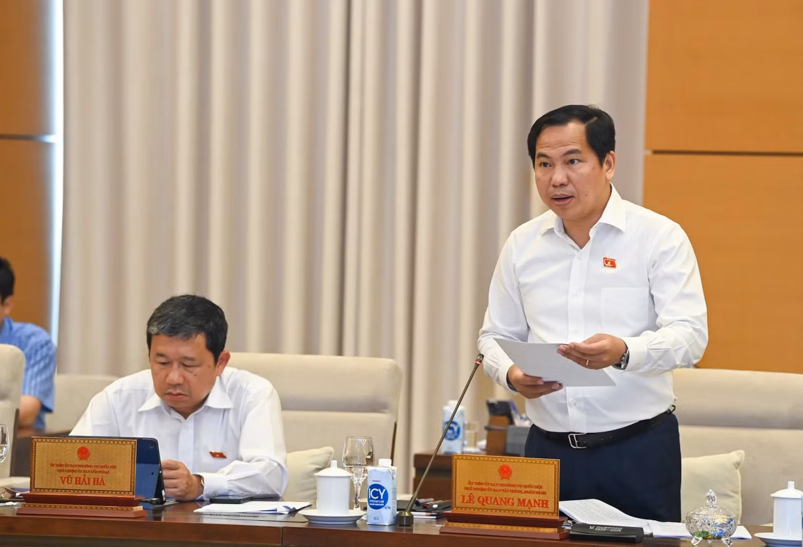 Chairman of the NA’s Finance and Budget Committee Le Quang Manh presents a review report.