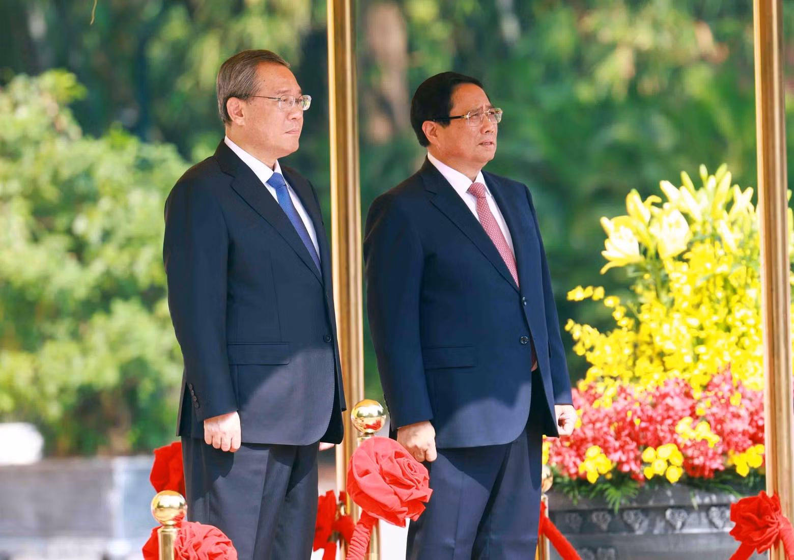 Prime Minister Pham Minh Chinh and Chinese Premier Li Qiang stand on the platform of honour as the military band plays the national anthems of both countries. (Photo: VNA)
