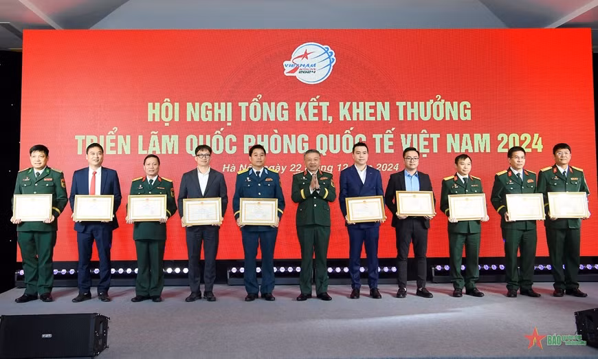 Senior Lieutenant General Le Quang Minh presents the Certificates of Merit from the Chief of the General Department of Politics of the Vietnam People's Army to the collectives that achieved outstanding results at the expo.