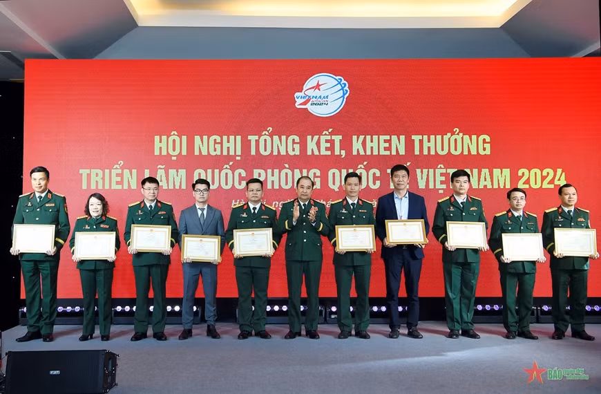 Senior Lieutenant General Phung Si Tan presents the Certificates of Merit from Chief of the General Staff of the Vietnam People's Army's to the collectives that achieved outstanding results at the expo.