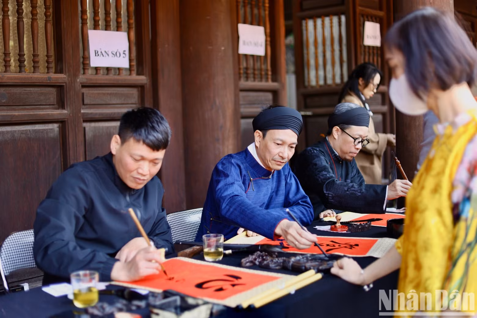 Calligraphers are writing and giving letters to visitors. This is the activity that tourists are most interested in when coming to the Temple of Literature.
