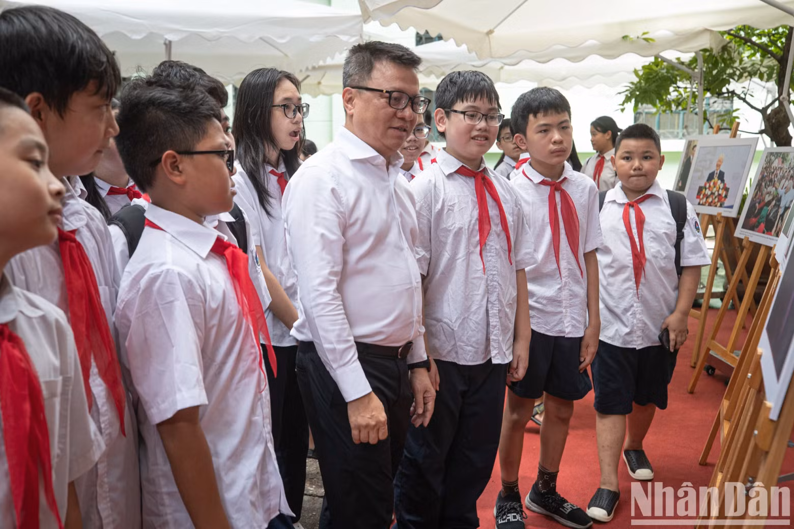 Editor-in-Chief Le Quoc Minh introduces the photo exhibition on late Party General Secretary Nguyen Phu Trong to students from Hoan Kiem Secondary School.