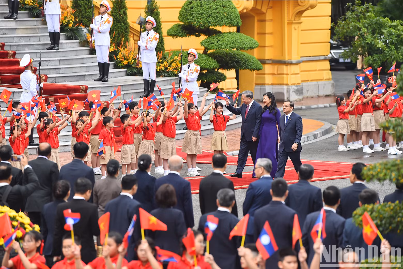Hanoi children wave flags to welcome Party General Secretary and President To Lam and his spouse.