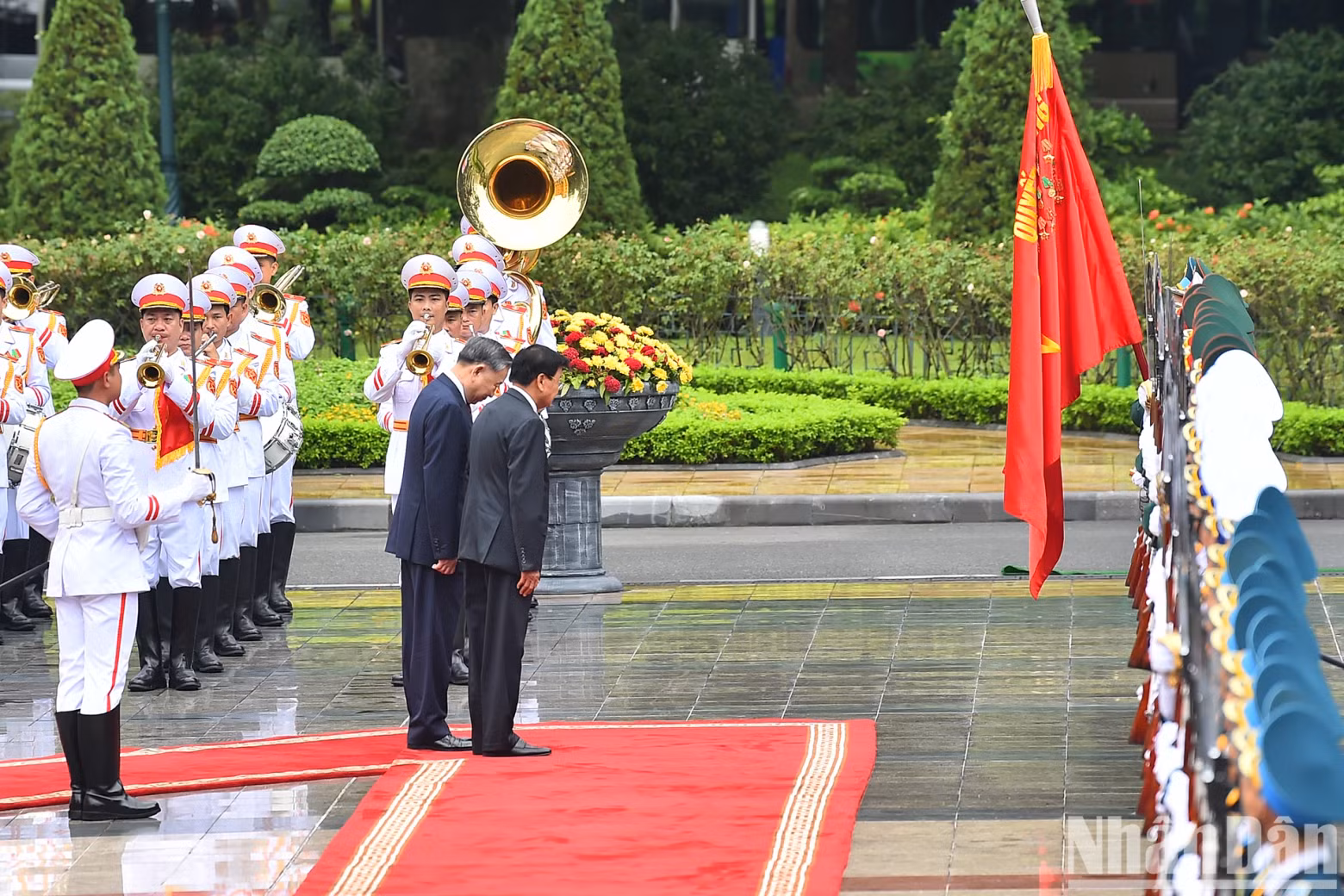 Party General Secretary and President To Lam and the LPRP General Secretary and President of Laos Thongloun Sisoulith perform the ceremonial salute to the Victory Flag of the Vietnam People's Army during the welcome ceremony.